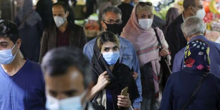 Iranians wear protective face masks to help prevent the spread of the coronavirus in the Tajrish traditional bazaar in northern Tehran Iran's official COVID death toll hits 35,298