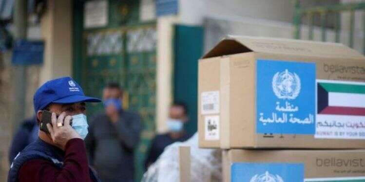 A local World Health Organization worker stands next to boxes of ventilators in Gaza City, Sunday Gaza gets vital medical aid as hospitals struggle with rising infections