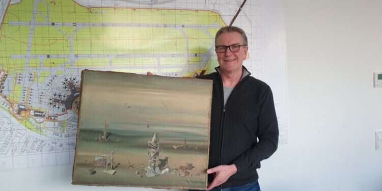 Chief Detective Michael Dietz holding the recovered painting from French artist Yves Tanguy, in Duesseldorf, Thursday Precious painting lost at German airport found at dumpster, returned to Israel