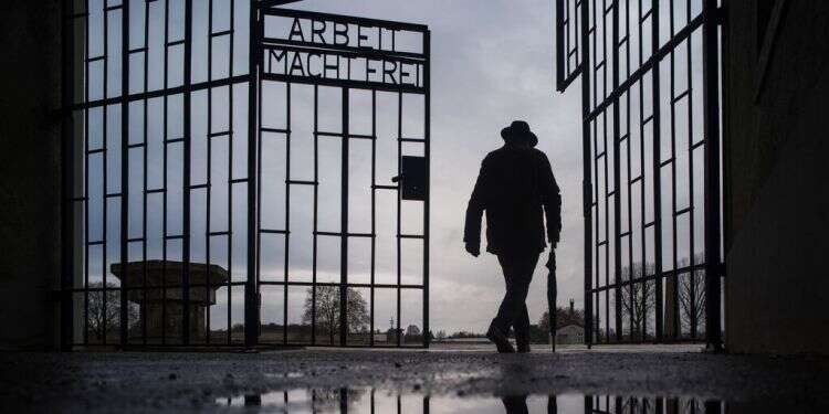 A man walks through the gate of the Sachsenhausen death camp Oranienburg, Germany 'Each survivor is a living example of the triumph of light over darkness'