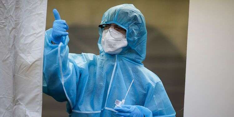 A healthcare worker is giving a thumbs-up sign Defeating COVID falls to all of us