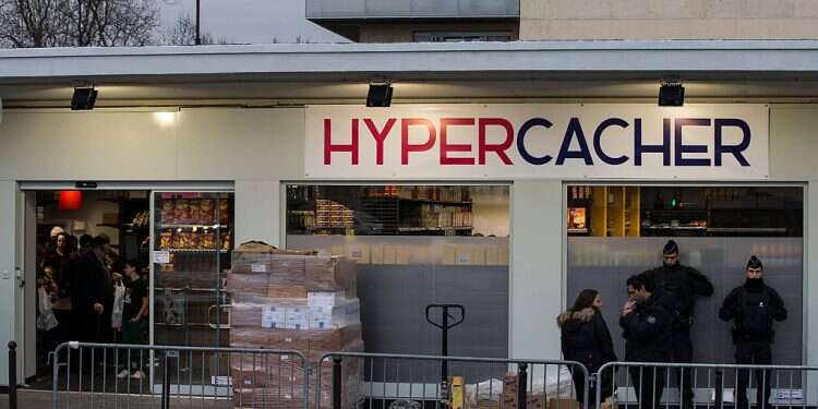 Police officers stand guard in front of the Hypercacher kosher supermarket during its reopening in Paris, France in March 2015 France decides to deport delivery driver who refused kosher food orders