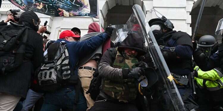 Riot police push back a crowd of supporters of US President Donald Trump after they stormed the Capitol building in Washington, Jan. 6, 2021 Biden's first goal is to stabilize American society