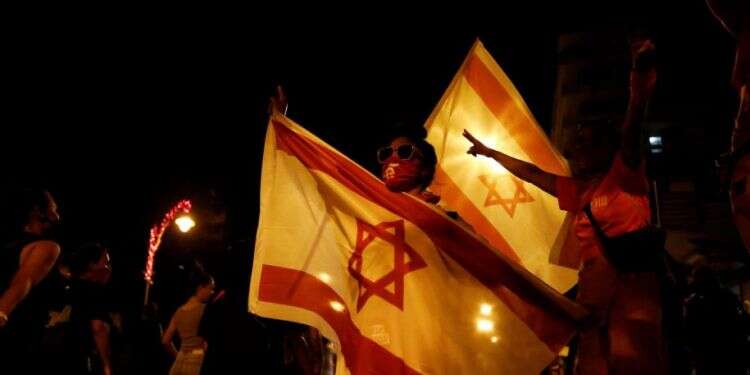 Members of 'The Pink Front,' a group of protesters demanding Israeli Prime Minister Benjamin Netanyahu to step down over corruption allegations, hold Israeli flags during a weekly anti-Netanyahu demonstration, in Jerusalem, Oct. 24, 2020 At anti-Netanyahu protests, pink is the new black