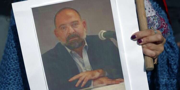 An anti-Hezbollah protester holds a picture of Lokman Slim Lebanese critic of Hezbollah found fatally shot
