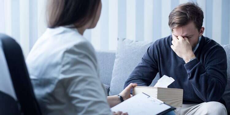Photo of professional female counselor helping depressed man *** Local Caption *** 23.07.19 JCT partners with McLean Hospital to reduce stigma around mental illness