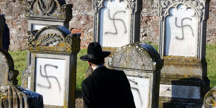 Chief Rabbi Harold Abraham Weill looks at graves desecrated with swastikas at the Jewish cemetery in Westhoffen, near Strasbourg, France, Dec. 4, 2019 US report names European countries failing to tackle antisemitism
