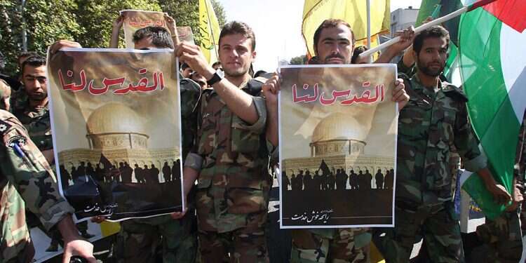 Iranian soldiers carry posters bearing a picture of the Dome of the Rock and reading in Arabic 'Jerusalem is ours' during a demonstration after special Friday prayers at Tehran University to mark Quds Day in 2007 Iranian TV: Zionists exploited Holocaust 'myth' to found Israel