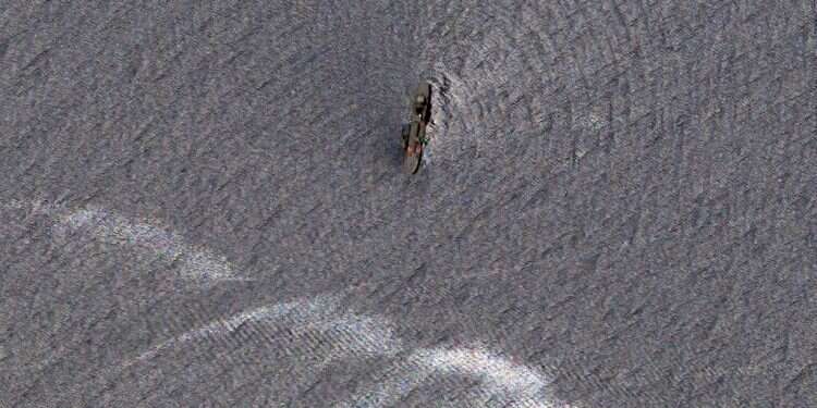 Oil-slicked waters spread out from the partially sunk Iranian navy vessel Kharg in the Gulf of Oman off the coast of Jask, Iran, in this image from June 3, 2021 Satellite photos show wreckage of Iran's biggest warship