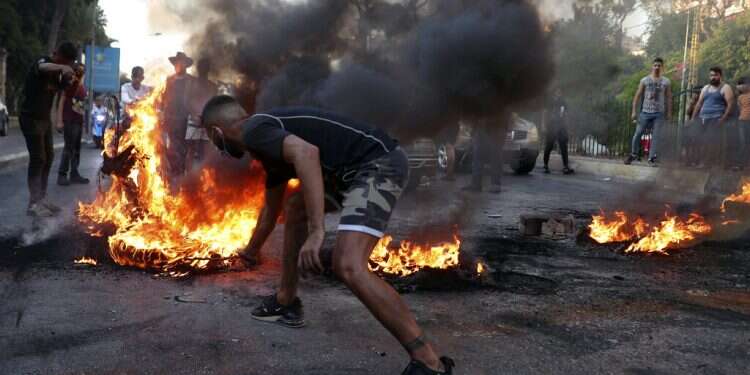 Protesters burn tires to block a road in Beirut on June 24, 2021 Lebanese riots sparked by failing economy injure protesters, security forces