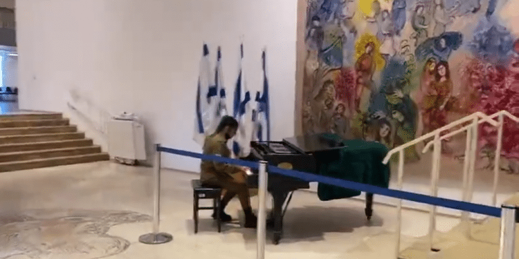 IDF Cpl. Einav Shenkar plays the piano during a tour of the Knesset IDF soldier stops Knesset tour to play a tune