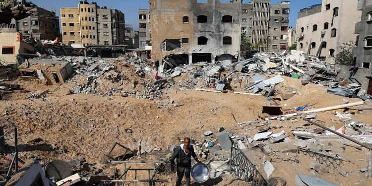 A Palestinian man walks amid buildings damaged by an Israeli airstrike in Beit Lahiya in the northern Gaza Strip, on May 20, 2021 World Bank estimates cost of rebuilding Gaza at $485M