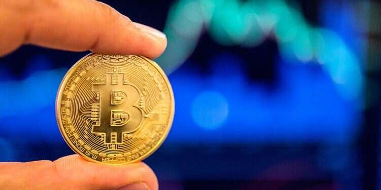 A person holding a visual representation of the digital crypto-currency Bitcoin, at the 'Bitcoin Change' shop in Tel Aviv on Feb. 6, 2018 TASE UP platform launches first Bitcoin-linked, backed bonds