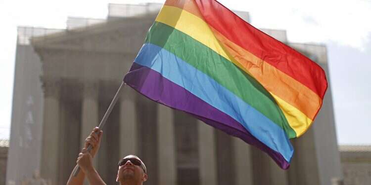 An LGBTQ activist waves a pride flag outside the US Supreme Court Hungary adds new restrictions on sale of LGBTQ-themed books