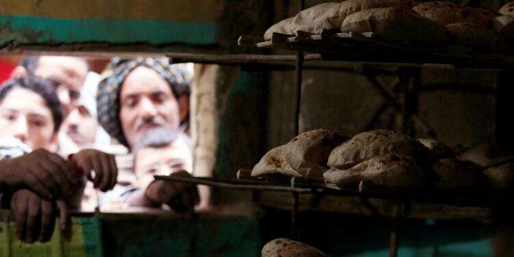 Men wait in line to buy subsidized bread at a bakery in Cairo, January 8, 2015 Egyptian bread price hike alarms the poor