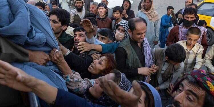 Displaced Afghans reach out for aid at a makeshift IDP camp in Kabul, Aug. 10, 2021 UAE evacuates 28,000 Afghans fleeing Taliban