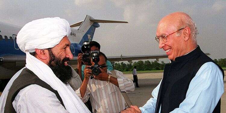 Then-Afghan Foreign Minister Mullah Mohammad Hassan Akhund us greeted by Pakistani FM Sartaj Aziz at an Air Force base in Rawalpindi, 25 kilometers from Islamabad, Aug. 25, 1999 Concerns rise as Taliban presents all-male cabinet of hardline old guard members