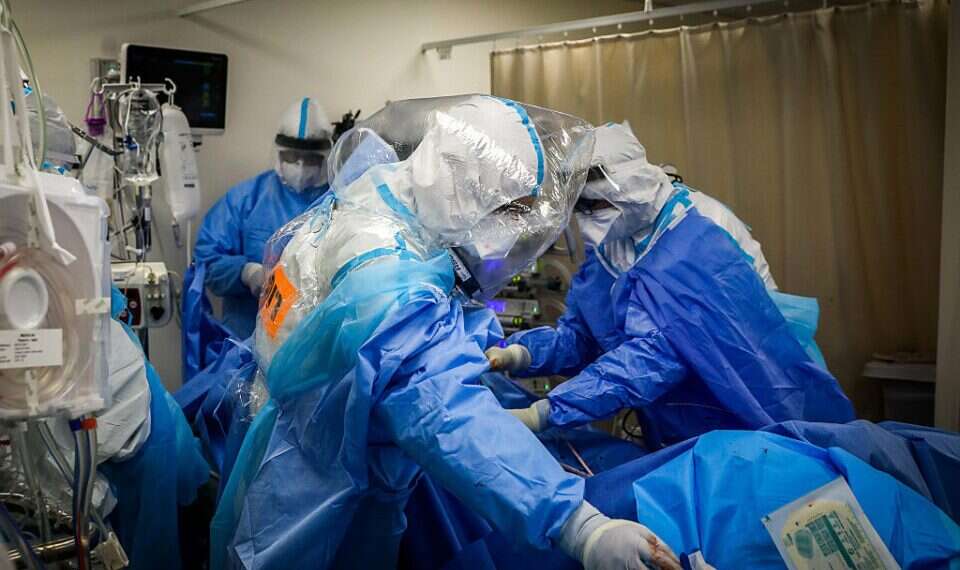 Medical personnel treat a COVID patient at Shaare Zedek Medical Center, Aug, 19, 2021 Israel breaks infection record as over 11,000 test positive for COVID