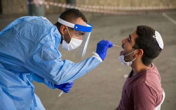 A medical worker performs a coronavirus test in Ashdod, Sept. 22, 2021 Pfizer submits COVID vaccine data on kids aged 5 to 11 to FDA