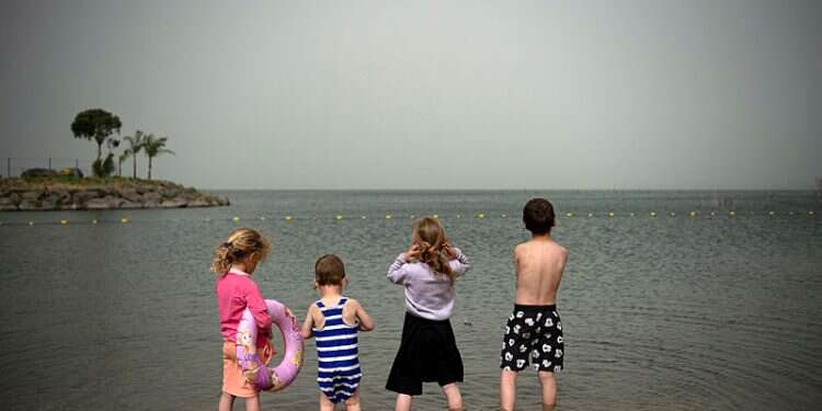 Children stand in the Sea of Galilee in northern Israel Israel's bleak summer: 35 children, teens, die in accidents over school break