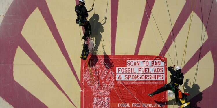 Greenpeace climate activists stage a protest at a Shell refinery in Rotterdam, Netherlands, Oct. 4, 2021 'Fossil fuel adverts belong in a museum,' activists demand