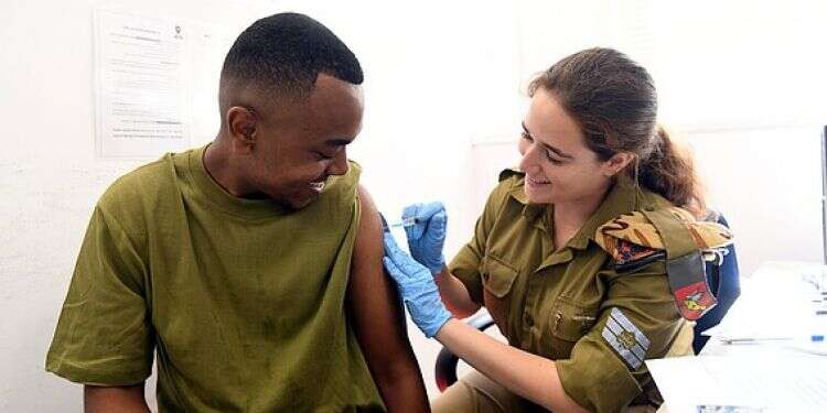 Military nurse vaccinating an IDF soldier US eyes Israeli military data for COVID booster safety