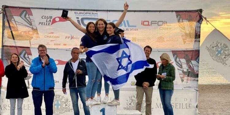 Members of Israel's national windsurfing team pose on a podium Israeli windsurfer makes splash at European championship