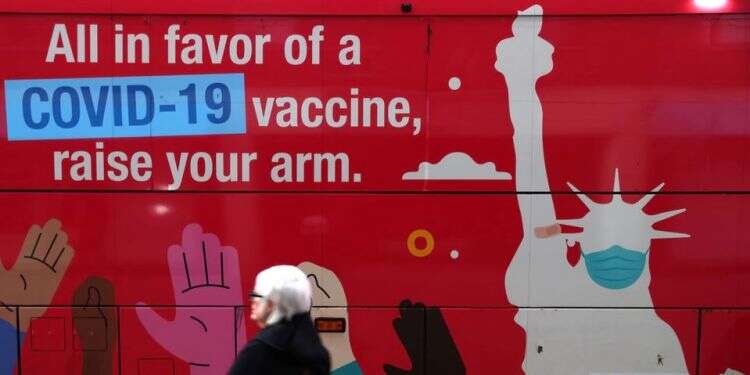 A person walks past a mobile COVID-19 vaccine clinic, Dec. 7, 2021, in New York, United States PM eyes imposing restrictions on unvaccinated Israelis