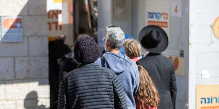 People wait for PCR tests at a branch of the Meuhedet HMO on Jan. 6, 2022 Israel could see up to 2 million COVID cases within 2 weeks, researchers warn