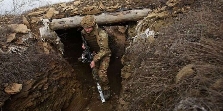 A Ukrainian serviceman walks along a trench at a position on the front line with Russia-backed seapratists As Russia takes military action, Western nations hit back with first wave of sanctions