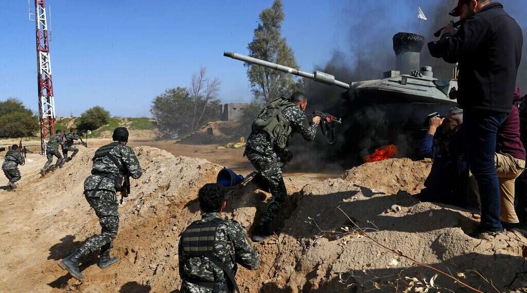 Palestinian actors dressed as Hamas terrorists attack a replica of an Israeli tank while a crew from the Hamas-run al-Aqsa satellite channel shoots for a 30-episode series, titled “Fist of the Free,” in Beit Lahiya, northern Gaza Strip, Thursday, Feb. 3, 2022 In answer to 'Fauda,' Hamas TV series glorifies fight against Israel