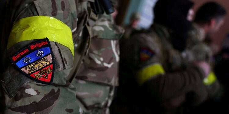 A badge on a uniform of a foreign fighter from the UK as they are ready to depart towards the front line in the east of Ukraine, March 5, 2022 For foreign fighters, Ukraine offers purpose, camaraderie and a cause