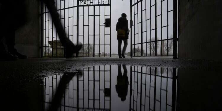 A person entes the Sachsenhausen Nazi death camp through the gate with the phrase 'Arbeit macht frei' (work sets you free) in Oranienburg, about 30 kilometers (18 miles) north of Berlin, Germany, on Jan. 25, 2022 Slovakia parliament condemns deportation of Jews in WWII