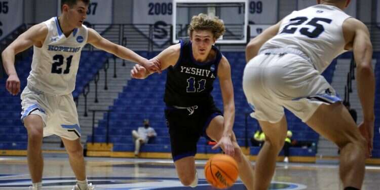 Yeshiva University's Ryan Turell (11) dribbles the ball down court while being defended by Johns Hopkins University's Carson James (21) and Lincoln Yeutter (25) in the first round of the NCAA's Division III basketball tournament, in Galloway Township, NJ, on March 4, 2022
Yeshiva U. 'Macs' end three-year streak in loss to Johns Hopkins