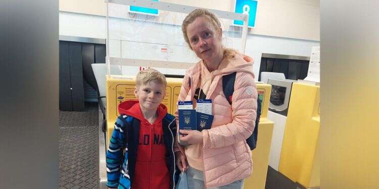 Arseny and his mother Svetlana Malavsky pose at the airport with their Ukrainian passports Ukrainian boy suffering from mysterious illness treated in Tel Aviv