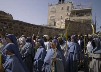 Nuns walk in the Palm Sunday procession on the Mount of Olives in Jerusalem, Sunday, April 10, 2022 Christians mark Palm Sunday with Jerusalem procession