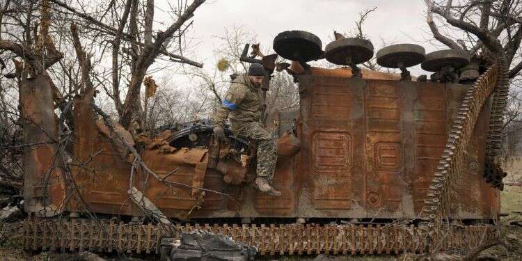 A Ukrainian serviceman jumps from a destroyed Russian combat vehicle after collecting parts and ammunition in Andriivka, Ukraine, April 6, 2022 Ukraine calls for West to send 'weapons, weapons, weapons'