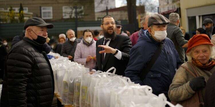 Rabbi Yehuda Teichtal, center, gives instructions during preparations for the celebration of Passover at the Chabad Jewish Education Center in Berlin, April 7, 2022 Chabad mobilizes to help Ukrainian Jews celebrate Passover