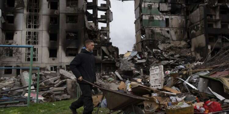 A young man pushes a wheelbarrow in front of a destroyed apartment building in the town of Borodyanka, Ukraine, April 10, 2022
Slovakia denies Russian claims it hit air defense systems in Ukraine ahead of eastern push