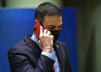 Spain's Prime Minister Pedro Sanchez speaks on his cell phone during a round table meeting at an EU summit in Brussels, on July 20, 2020 Spain fires intelligence chief amid Pegasus hacking scandals
