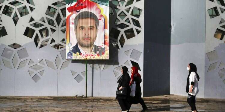 People walk past a banner showing IRGC Col. Hassan Sayyad Khodaei prior to his funeral ceremony in Tehran on Tuesday, May 24, 2022 Israel caught off guard by US leak about alleged assassination of top IRGC official
