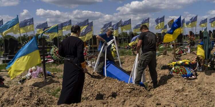 Undertakers lower the coffin of Ukrainian serviceman Oleksander Matyukhin, 32, in Kharkiv, eastern Ukraine, May 23, 2022 Ukraine says 6 civilians killed as Russia focuses fire in east
