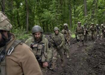 Ukrainian servicemen walk in the forest near a recently retaken village, north of Kharkiv, east Ukraine, Sunday, May 15, 2022 Britain says Russia has lost one-third of its forces in Ukraine