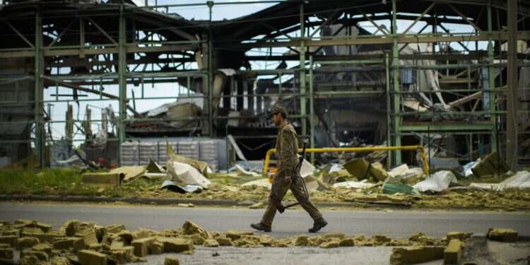 A Ukrainian serviceman walks past a gypsum manufacturing plant destroyed in a Russian bombing in Bakhmut, eastern Ukraine, May 28, 2022 Ukrainian official: 'Corrupt' Israeli ministers doing business with Russia