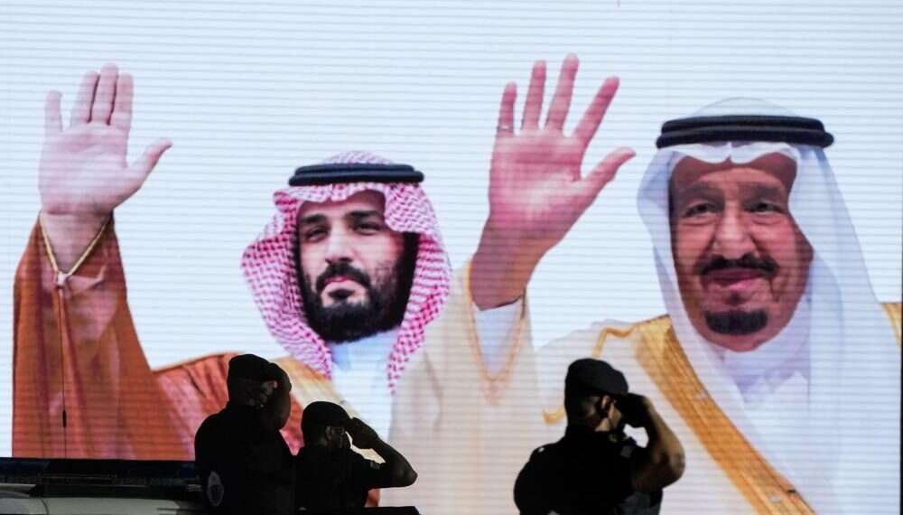 Saudi special forces salute in front of a screen displaying images Saudi King Salman and Crown Prince Mohammed bin Salman in Mecca, July 3, 2022 Biden seeks new chapter in troubled Middle East