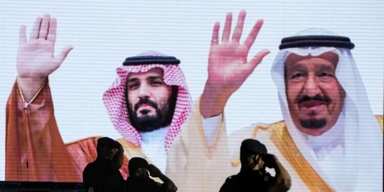Saudi special forces salute in front of a screen displaying images Saudi King Salman and Crown Prince Mohammed bin Salman in Mecca, July 3, 2022 Biden seeks new chapter in troubled Middle East