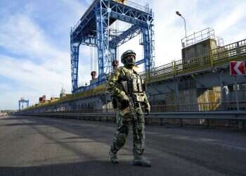 A Russian soldier patrols an area at the Kakhovka Hydroelectric Station, a run-of-river power plant on the Dnieper River in Kherson region, south Ukraine Drone explosion hits Russia's Black Sea Fleet headquarters