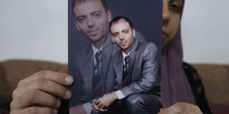 Dalal, the wife of Khalil Awawdeh, a Palestinian prisoner in Israel, displays his picture at the family house west of Hebron, Aug. 17, 2022 Palestinian prisoner on hunger strike reported in 'critical condition'