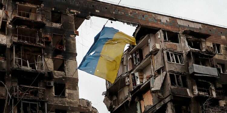 A view shows a torn flag of Ukraine hung on a wire in front an apartment building destroyed during Ukraine-Russia conflict in the southern port city of Mariupol, Ukraine April 14, 2022 Russian rabbis call for peace in Ukraine