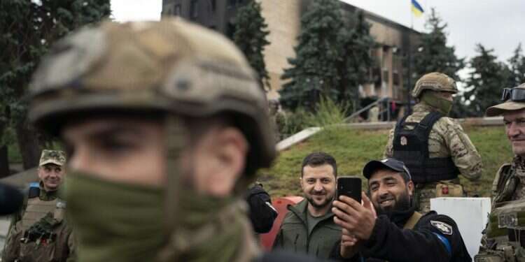 Ukrainian President Volodymyr Zelenskyy poses for a selfie with a police officer after attending a national flag-raising ceremony in the freed Izium, Ukraine, Sept. 14, 2022 Putin, Zelenskyy court major allies as Ukraine makes gains